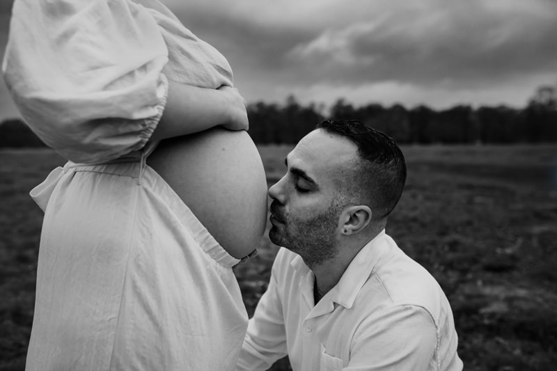 London Family Photographer, Husband kisses pregnant wife's belly