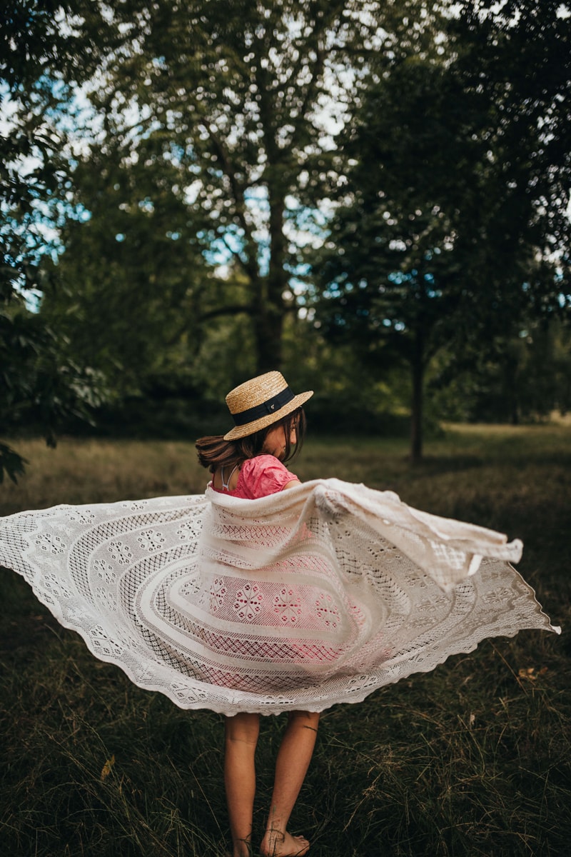 London Family Photographer, a young girl twirls her blanket through the air in the outdoors